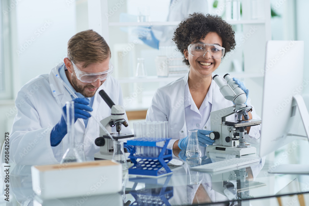 Smiling scientists looking at camera arms crossed in laboratory Smiling scientists looking at camera arms crossed in laboratory