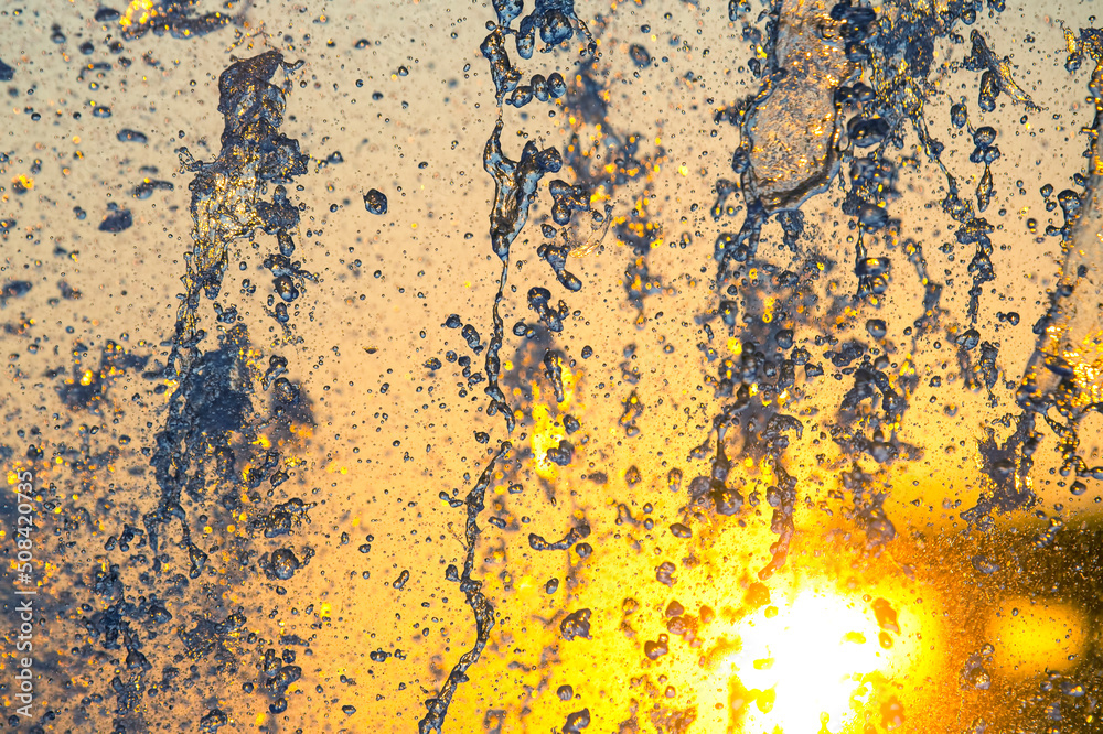silhouettes of drops falling water fountain against the backdrop of the setting sun silhouettes of drops falling water fountain against the backdrop of the setting sun