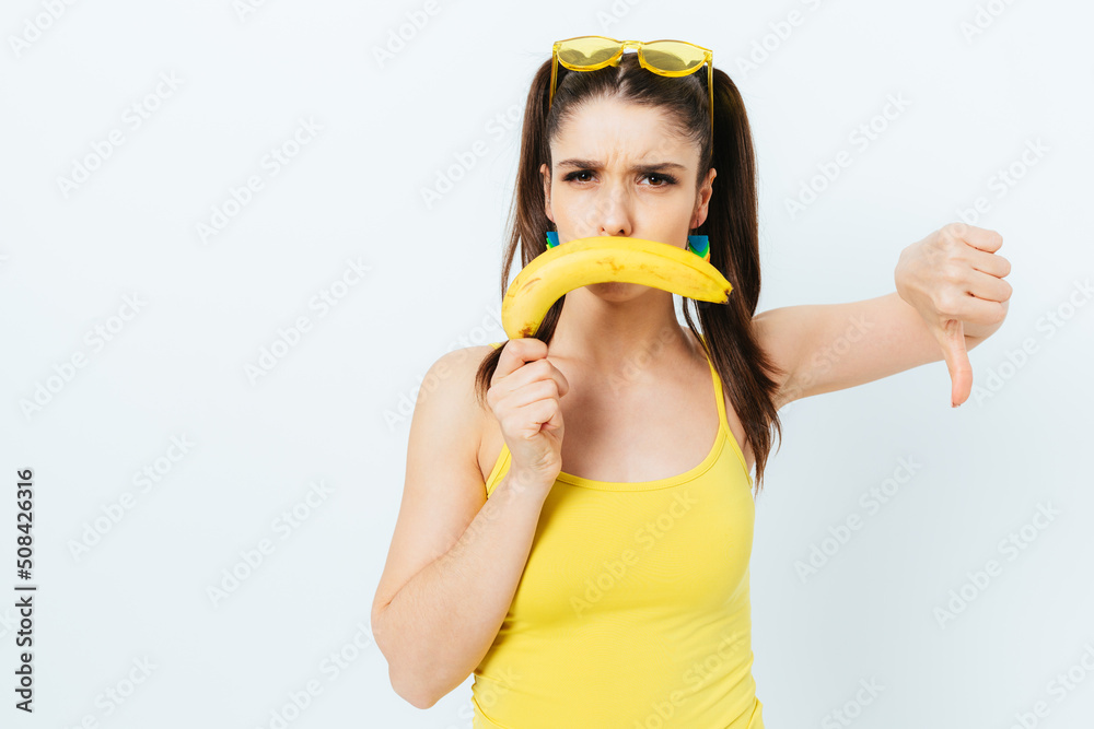 Portrait displeased young woman in studio wearing summer outfit Portrait displeased young woman in studio wearing summer outfit