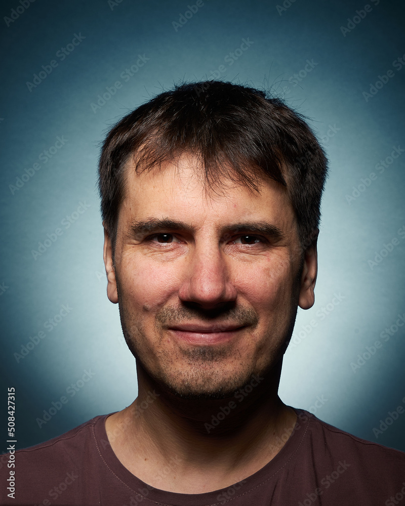 Portrait of a 42-year-old brunette man on a dark background with bright illumination Portrait of a 42-year-old brunette man on a dark background with bright illumination