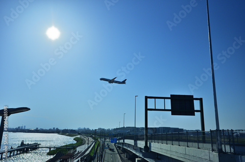 多摩川スカイブリッジから見る羽田空港から青空に飛び立つジェット機