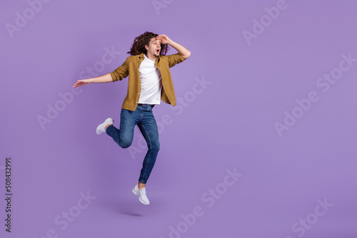Full body profile side photo of young guy amazed shock look empty space jumper isolated over purple color background