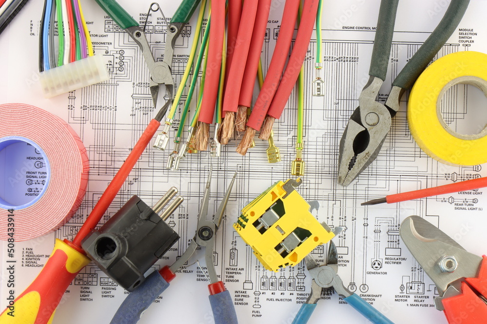 Tools for installing an electrical control panel in close-up on an electrical diagram.