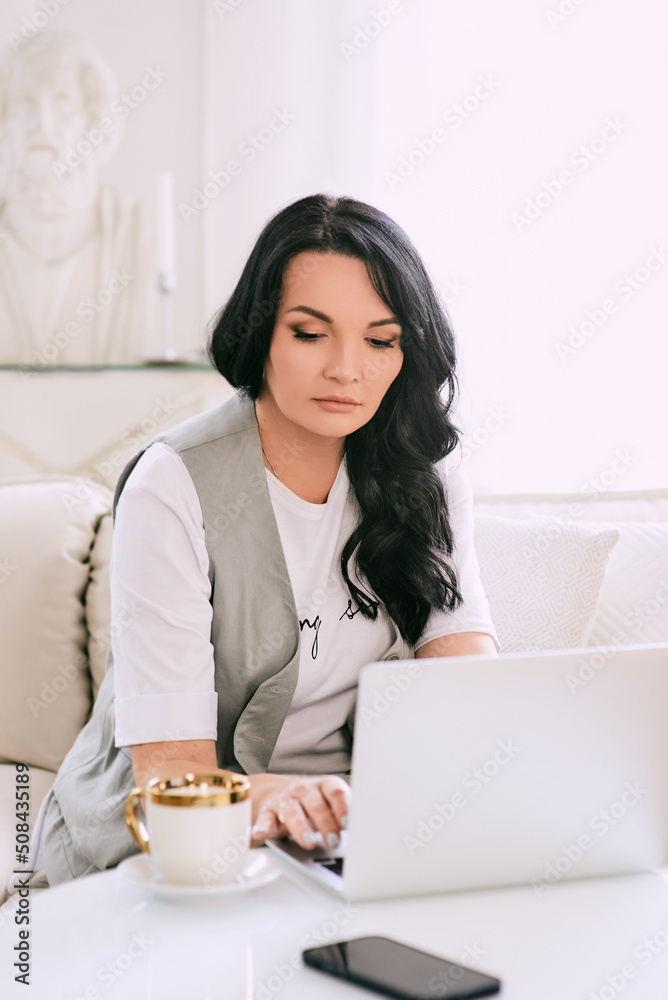 woman sitting on the sofa and making notes in her notebook. Business, analytics, education woman sitting on the sofa and making notes in her notebook. Business, analytics, education