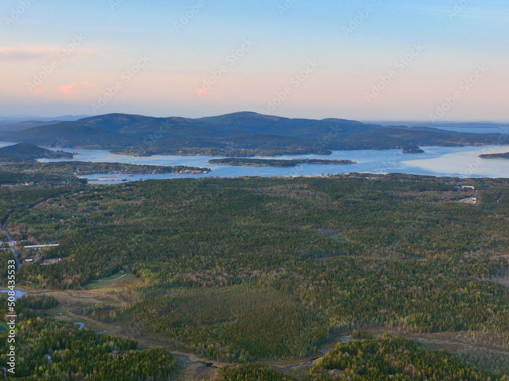 Fototapeta premium Somes Sound and Bass Harbor village aerial view at sunset with Cadillac Mountain in Acadia National Park at the background in town of Tremont on Mt Desert Island, Maine ME, USA. 