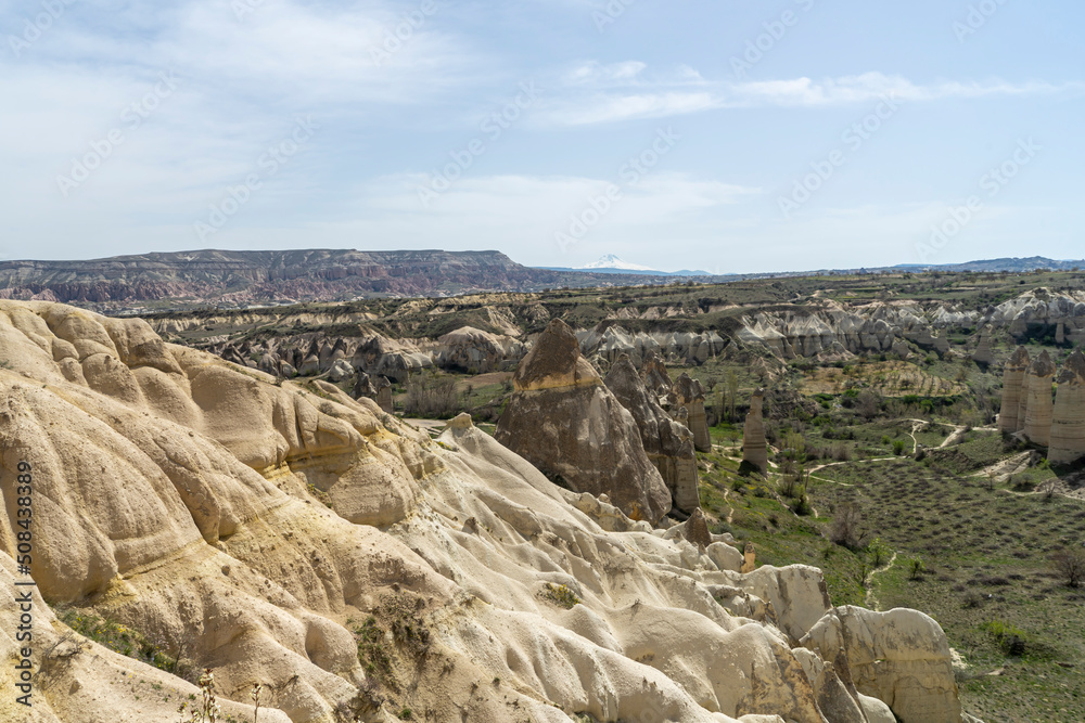 View of the Goreme National Park, Cappadocia, with natural wonders from Love Valley. Erciyes mountain is visible on the background. 