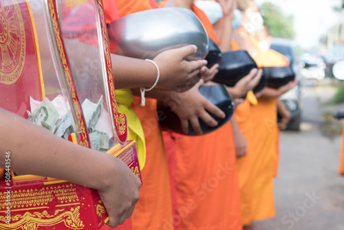  Novice monks hold alms bowls waiting for people to offer food to monks in the morning in Thailand.