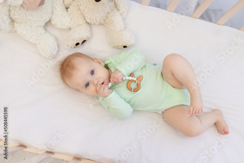 Wallpaper Mural cute baby in crib with teether in bedroom in green bodysuit Torontodigital.ca