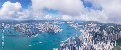 Epic aerial view of the Victoria Harbour in a clear day, with thick cloud and sunlight