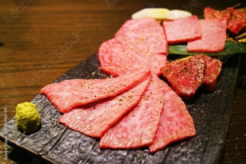 Fresh red tender high-grade beef with beautiful snowflakes is sliced according to different parts on a black plate