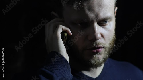 man is talking on the phone in the dark, the concept of blackmail and loan debts.