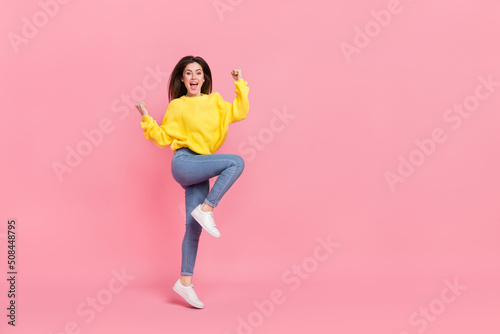 Full length photo of young cheerful girl rejoice luck triumph fists hands isolated over pink color background
