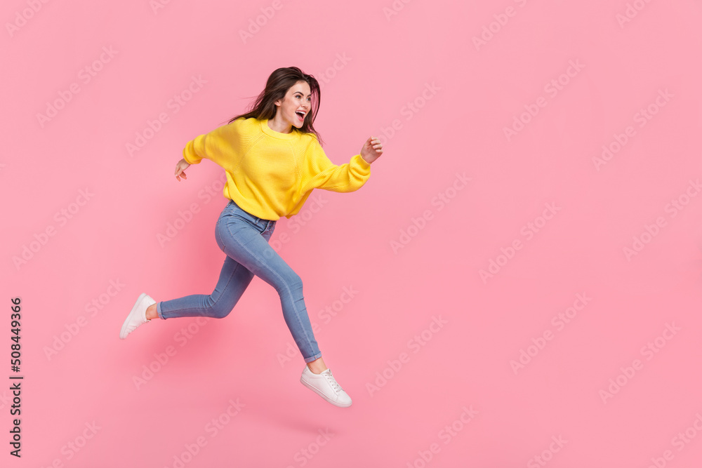 Full size profile side photo of young excited lady hurry movement jump look empty space isolated over pink color background Full size profile side photo of young excited lady hurry movement jump look empty space isolated over pink color background