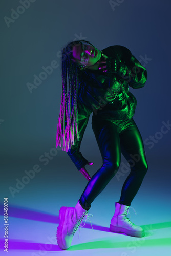 Full length of stylish african american woman in smart glasses on blue background. © LIGHTFIELD STUDIOS