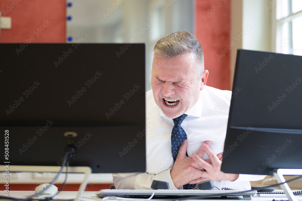 Businessman suffering a heart attack in the office
