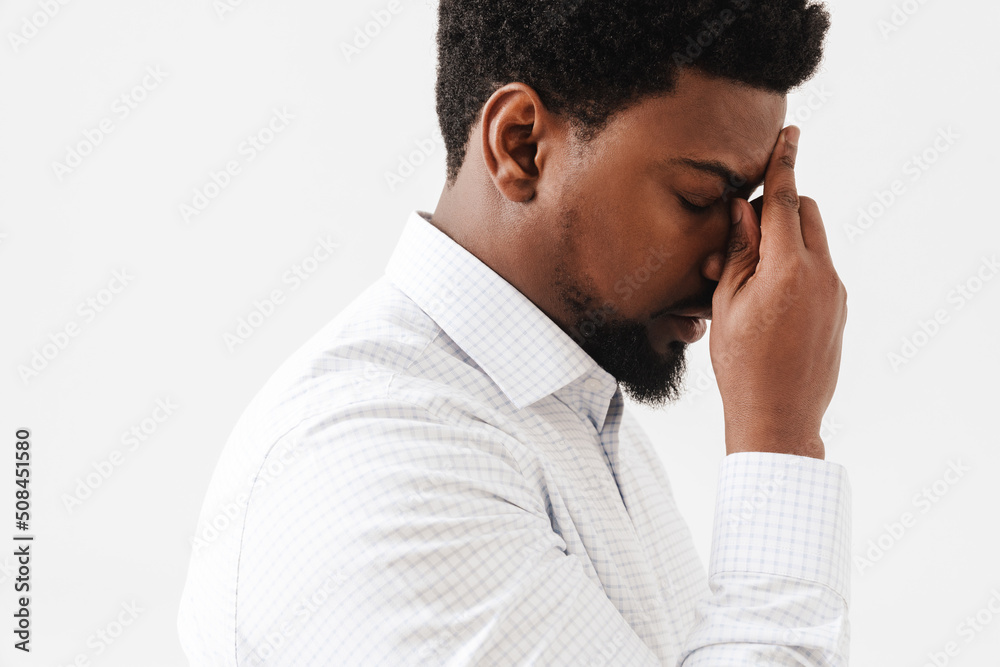 Black tired man with headache rubbing his forehead