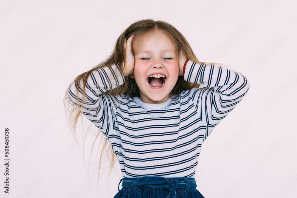Portrait of little girl holding hands on head, screaming with opened mouth and crazy expression. Surprised or shocked face Portrait of little girl holding hands on head, screaming with opened mouth and crazy expression. Surprised or shocked face