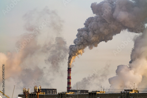 industrial chimneys with heavy white smoke causing air pollution problem 