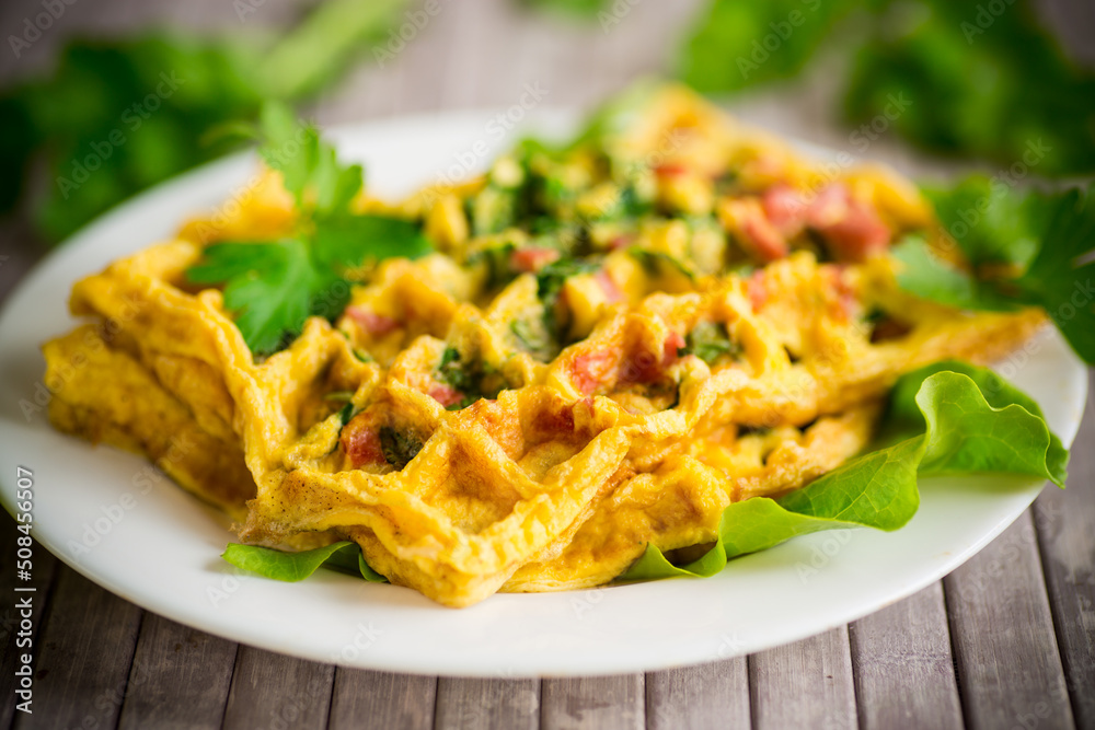 Fototapeta premium Egg omelet stuffed with greens and sausage fried in the form of waffles