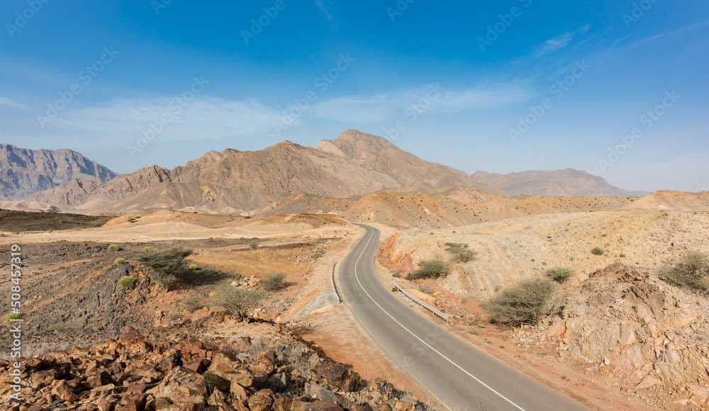 A road going thru the deserted mountains of the Sultanate of Oman. 