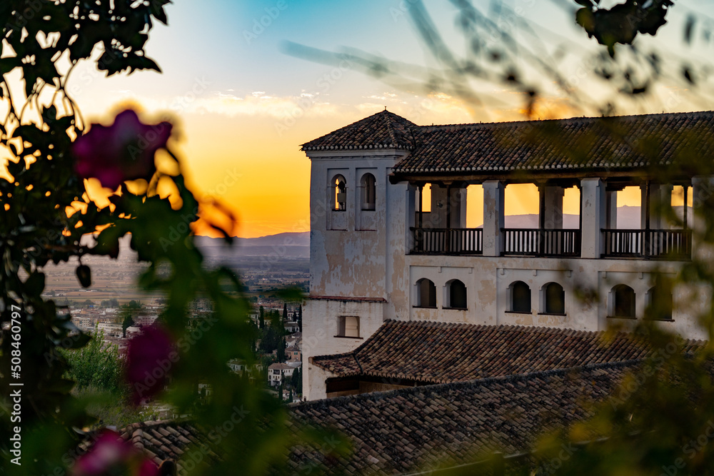 Obraz premium Alhambra at sunset with flowers in foreground, granada spain