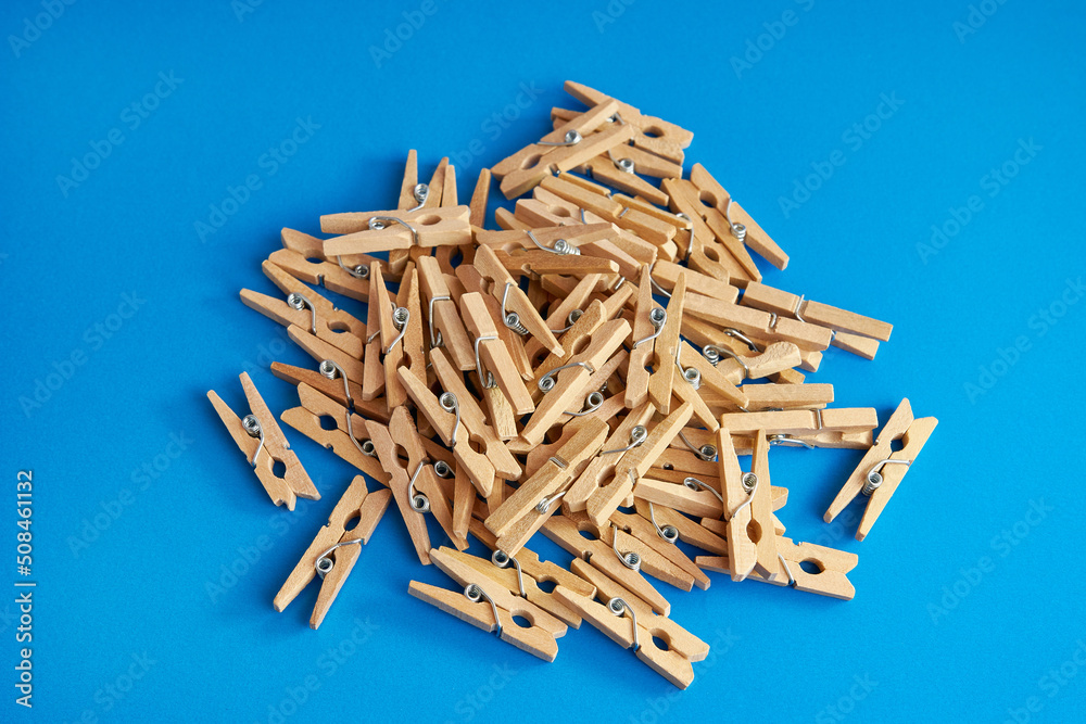 Little wooden clothespins on a blue background. Little wooden clothespins on a blue background.