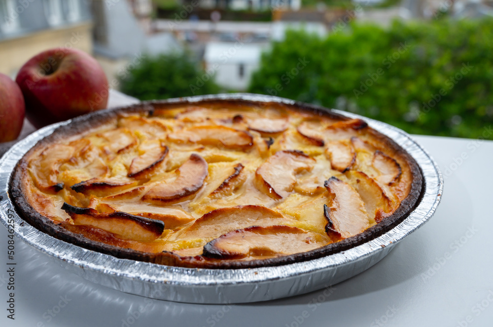 Tasty sweet French dessert, baked apple cake and view on old houses of