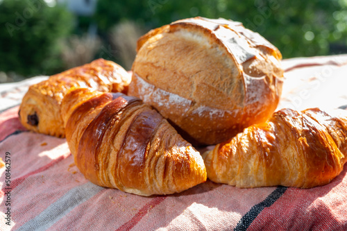 Two fresh baked butter croissants and whitre wheat farmers breasd from French bakery photo