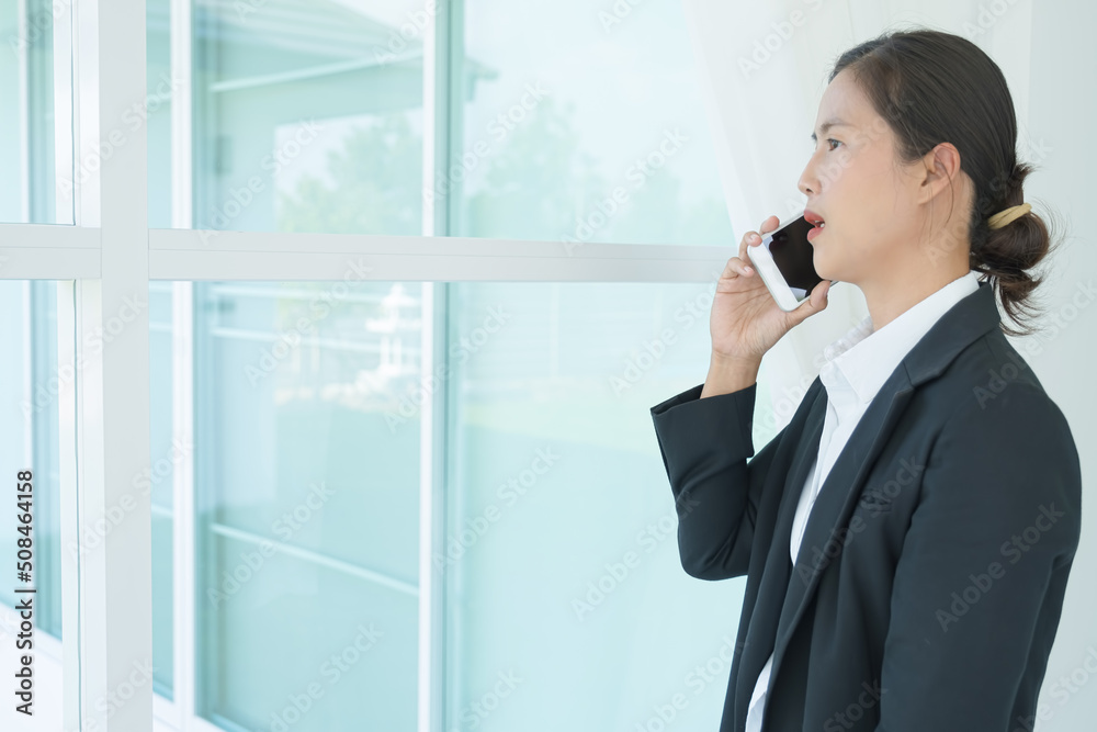 young business working and using laptop, holding smartphone in hand discussing the charts and graphs showing the results of their successful teamwork.