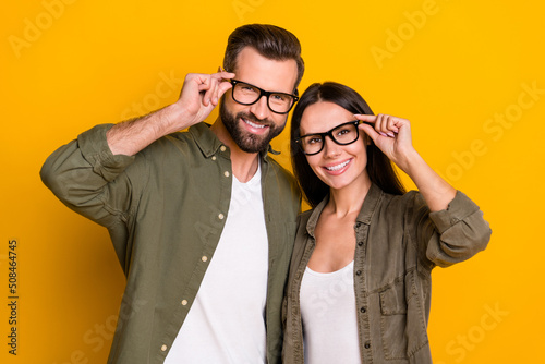 Photo of young cheerful couple intelligent eyewear oculist look vision isolated over yellow color background