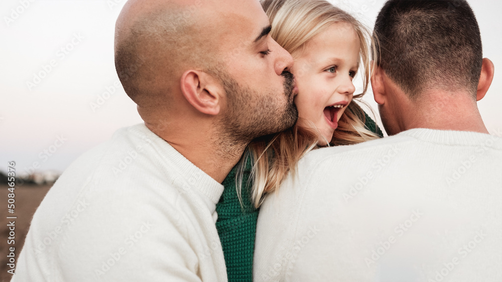 Gay male parents having tender moment kissing their son outdoor - Main focus on right father neck - LGBT and love family concept Gay male parents having tender moment kissing their son outdoor - Main focus on right father neck - LGBT and love family concept