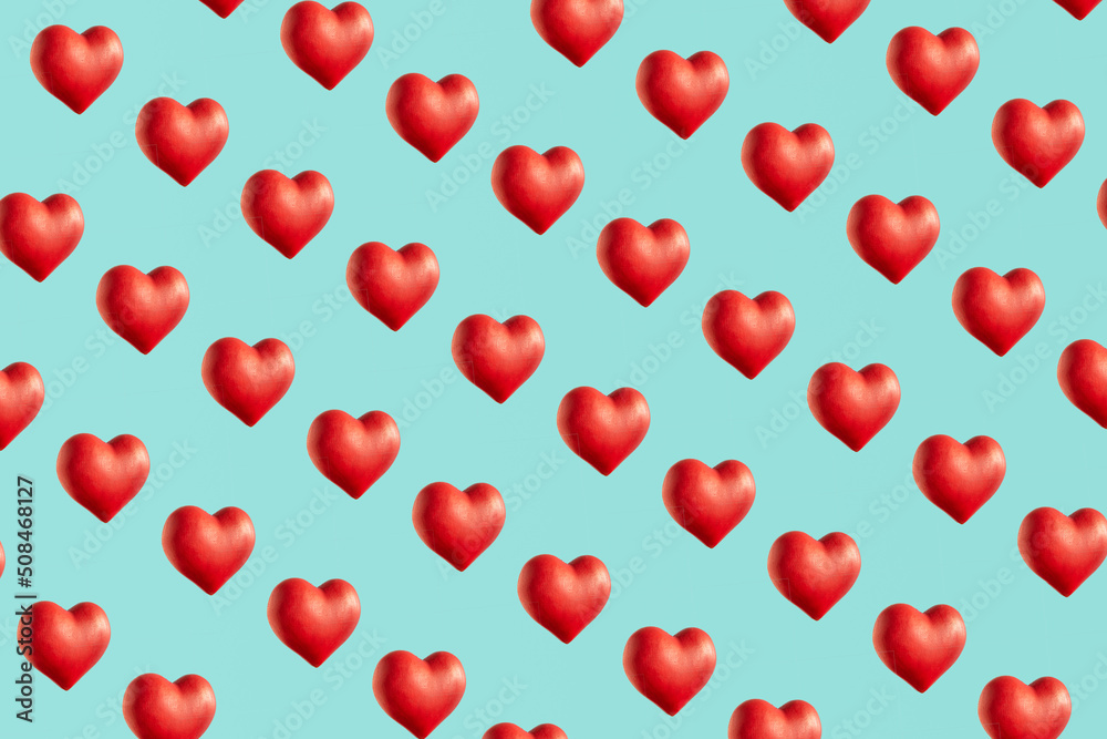 Red hearts, creative love and passion inspired pattern on pastel blue background.