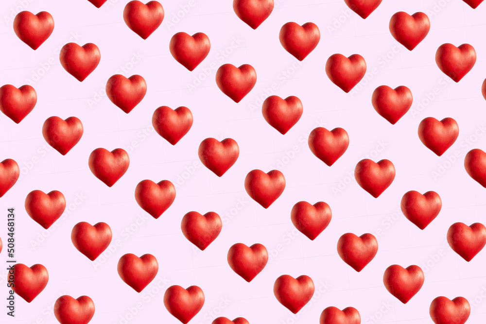 Red hearts against pastel pink background, creative pattern, Valentine's day idea. 