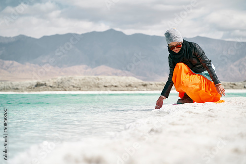 asian woman touching the water of a salt lake photo