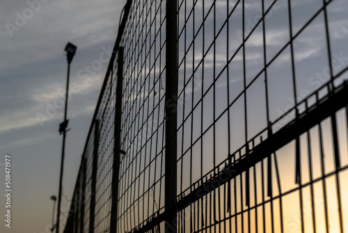 large fence with street light against sunset