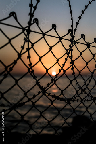 barbed wire against sunset