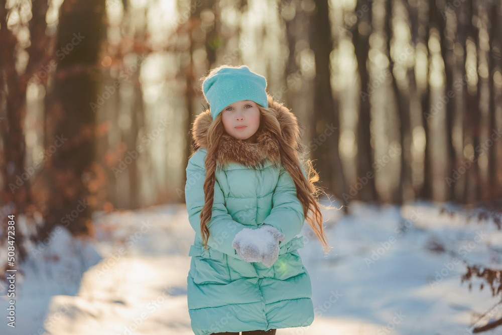 happy girl in turquoise jacket and hat
