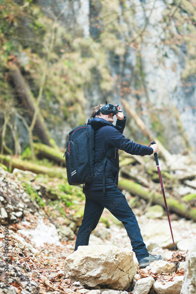 Cyber hiking take a hike outdoors with a headset on and visit nature in a virtual environment. Virtual traveler in different universes like the multiverse or metaverse wear virtual reality glasses