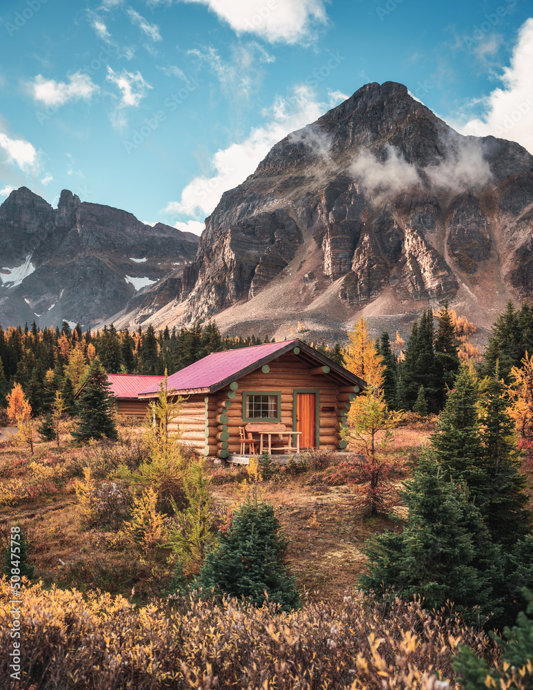 Wooden hut with rocky mountains in autumn forest on national park