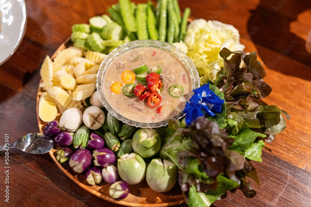 Salted fish dipping sauce with Thai herb and vegetables mixed on wooden tray