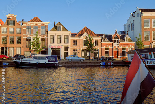 Haarlem, Netherlands - May 23. 2022: Panoramic view of traditional Dutch houses in a row lining the river Sparne in the summer.