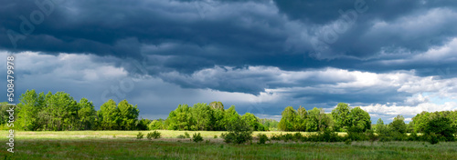 dark storm clouds over the meadows, panorama photo