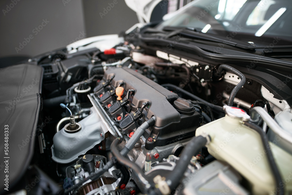 Modern petrol engine close up. New 4 cylinder motor during service. Closeup of cylinder block head Modern petrol engine close up. New 4 cylinder motor during service. Closeup of cylinder block head