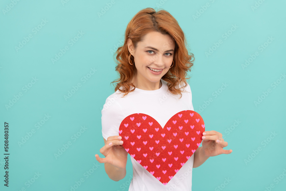 positive redhead lady hold red heart on blue background positive redhead lady hold red heart on blue background