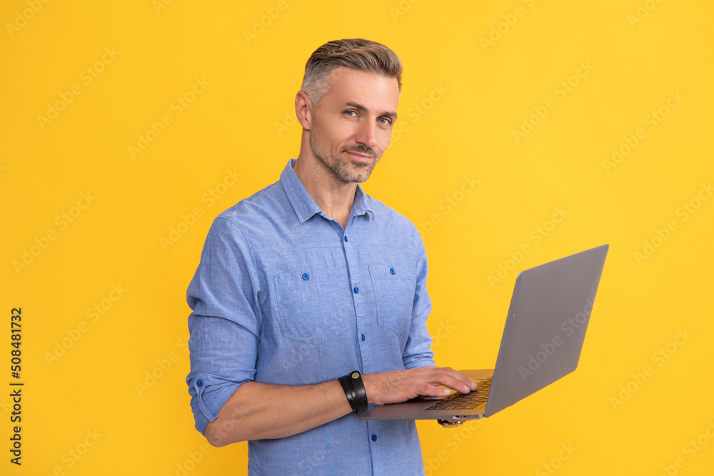 adult man working online on laptop on yellow background, entrepreneur adult man working online on laptop on yellow background, entrepreneur