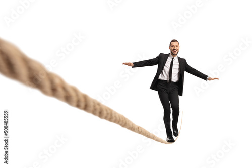Businessman walking on a tightrope and smiling photo