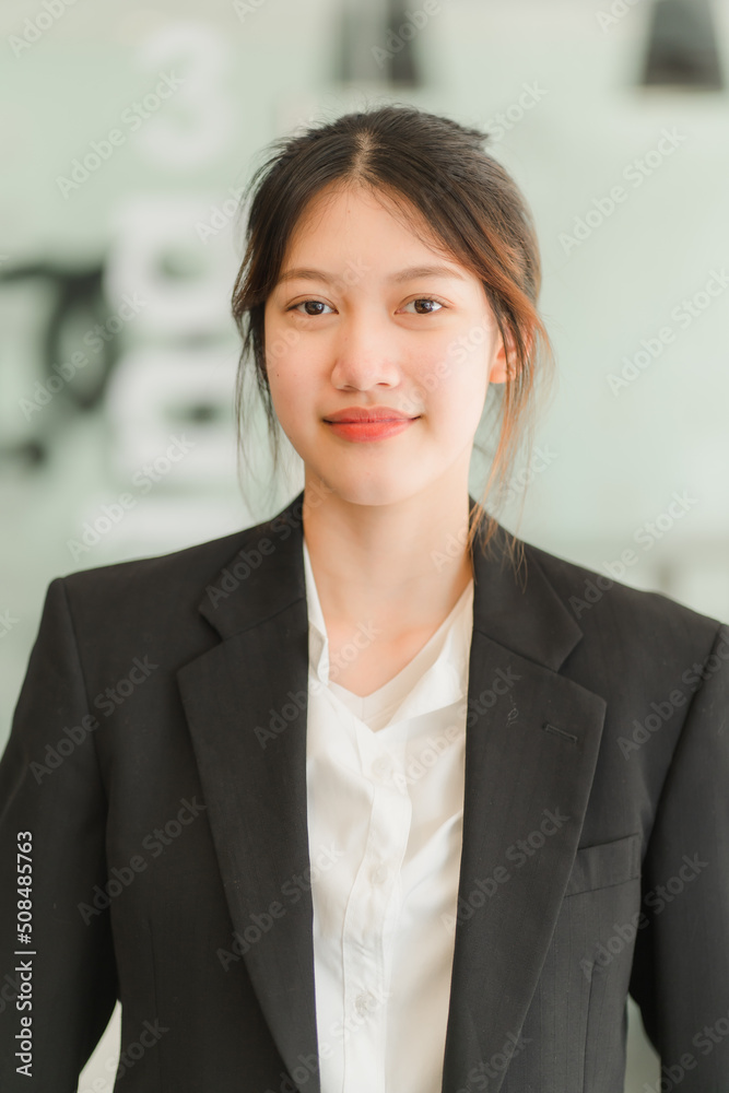 A saleswoman checks the lease and holds a small gray model of house and house keys in preparation for meeting customers to sign the lease. Real estate leasing concept.