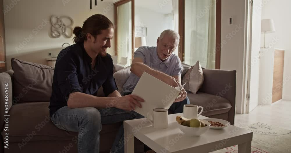 Father and son examining photos together Father and son examining photos together