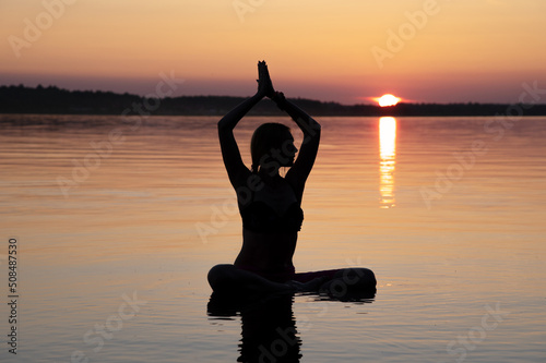 Woman practice Yoga on the beach, Sunset evening
