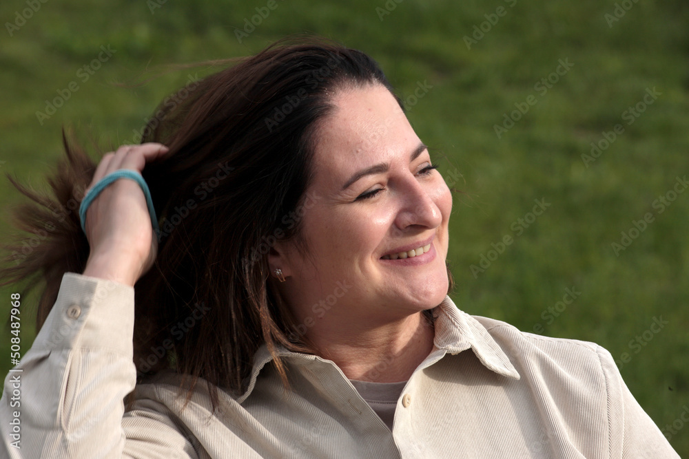 Happy woman near the forest in nature in warm clothes at sunset